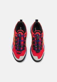 Rote Sportschuhe verfügen über ein Obermaterial aus Mesh mit schwarzen und orangefarbenen Akzenten, blauen Schnürsenkeln und einer strukturierten weißen Zehenkappe. Schwarze Innenausstattung und strapazierfähige Sohle.