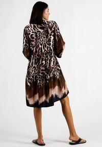 Leopardenmuster-Kleid mit einem gestuften Design, das eine braune und schwarze Farbpalette sowie eine luftige Silhouette aufweist, aus leichtem Material gefertigt.