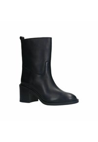 Bottes de cheville en cuir noir avec un bout arrondi, un petit talon carré et un design sans couture. Elles sont dotées d'une languette à l'arrière pour un enfilage facile.