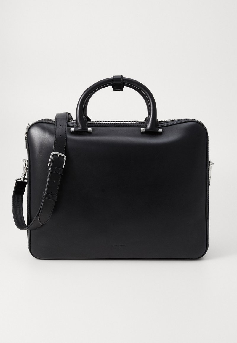 Schwarze Lederaktentasche mit glatter Textur, Reißverschluss, zwei oberen Griffen und abnehmbarem Schultergurt. Minimalistisches Design ohne erkennbare Muster.