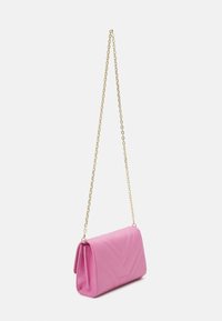 Borsa a tracolla trapuntata rosa con motivo a zig-zag, tracolla in catena dorata e forma rettangolare. Realizzata in materiale morbido con una texture liscia.