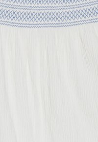 Abito bianco con tessuto a trama che presenta dettagli di arricciatura orizzontale in azzurro chiaro. Il materiale appare leggero e leggermente sgualcito.
