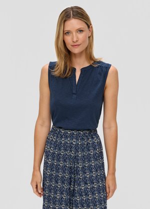 Navyblauwe mouwloze top met een notch kraag, gecombineerd met een gestreepte blauw en crème rok met een bloemontwerp. Zachte stoftextuur.