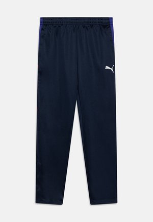 Hosen aus dunkelblauem Stoff mit glatter Textur. Mit elastischem Bund, weißem Logo auf dem linken Oberschenkel und lila Seiteneinsätzen.