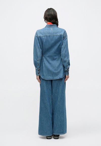 Σετ τζιν με λινό πουκάμισο μακριά μανίκια και παντελόνι με φαρδιά πόδια. Χρώμα ανοιχτό μπλε, με κουμπιά και γιακά.