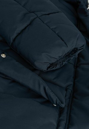 Marinblå puffjacka med quiltad textur, elastiska ärmslut och tryckknappsdetalj, tillverkad av ett slitstarkt, vattenavvisande material.