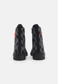 Mustade pahklu чул о adidas-  проигрываю серого цвета на фоне черной свету с красной треуголкой. Ботинки изготовлены из текстурированного материала и на прочной черной подошве.