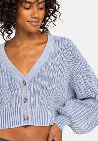 Lichtblauwe gebreide, cropped cardigan met een V-hals, voorzien van drie grote knopen en geribbelde afwerking, benadrukt door volume mouwen.