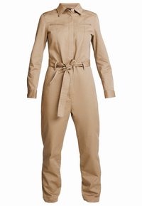 Beige overal s dlouhými rukávy, límcem, předními kapsami a šňůrkou v pase. Hladká textura s přiléhavým designem.