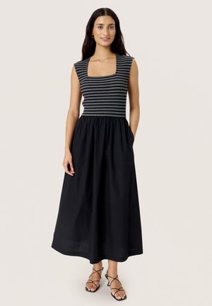 Schwarzes, knöchellanges Kleid mit einem taillierten, gestreiften Oberteil und einem ausgestellten Rock. Verfügt über einen quadratischen Ausschnitt und seitliche Taschen. Minimalistisches Design.