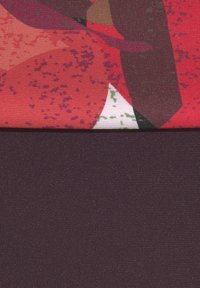 Textil med ett livfullt rött abstrakt mönster ovanpå; solidt mörklila tyg nedanför. Båda materialen har en mjuk textur.