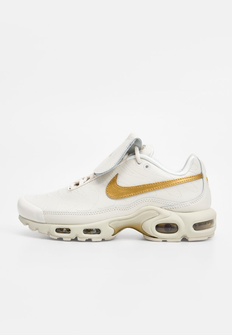 Weiße Ledersneaker mit goldenen Akzenten, gepolsterter Zunge, Luftpolsterung und strukturiertem Obermaterial mit gestickten Mustern.