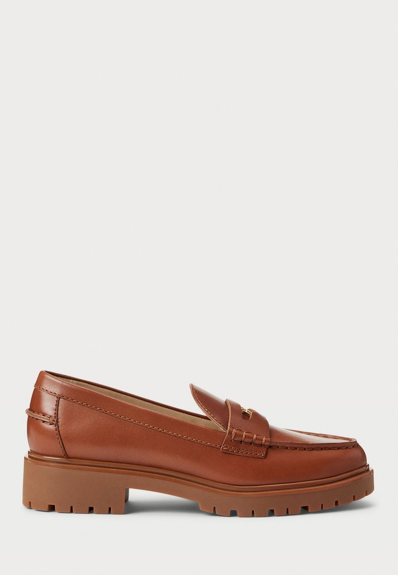 Brown leather loafers with a moccasin toe design, visible stitching, and a chunky, textured rubber sole. Gold-tone hardware accent.
