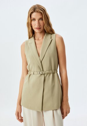 Hellgrüner ärmelloser Blazer mit V-Ausschnitt, taillierter Taille und strukturiertem Stoff. Verfügt über spitze Revers und einen taillierten Schnitt.