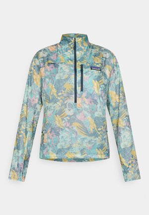 Chaqueta ligera tipo pulóver multicolor con un patrón floral, cierre frontal de media cremallera y herrajes en color azul marino. Confeccionada en tela texturizada con cuello alto.