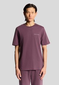 Purple cotton t-shirt with short sleeves, crew neck, and embroidered logo on the left chest. Smooth texture, relaxed fit.