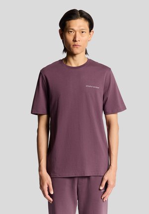 T-shirt en coton violet à manches courtes, col rond, et logo brodé sur la poitrine gauche. Texture lisse, coupe décontractée.