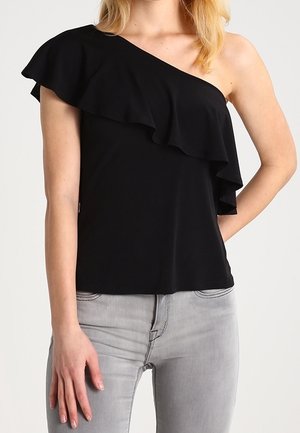 Zwarte one-shoulder top met gelaagde ruffles, gemaakt van zachte stof. Draagt met lichtgrijze jeans, die een relaxte pasvorm en een slank ontwerp laten zien.