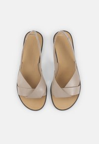Beige lærsandaler med kryssende stropper, en polstret innersåle og en liten hæl. Jevn tekstur med et minimalistisk design.