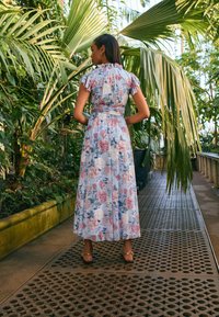 Ilgos suknelės šviesiai mėlynos spalvos audinys su gėlių raštais rožinės ir baltos spalvos. Raukinėti rankovės ir aptempta liemens linija su diržu.