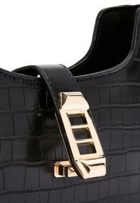 Borsa in pelle nera con effetto coccodrillo, dalla forma strutturata, arricchita da una fibbia rettangolare dorata e una superficie liscia sulla tracolla.