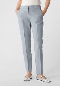 Lichtgrijze op maat gemaakte broeken met een soepele textuur, voorzien van zijzakken en een slim fit ontwerp. Gecombineerd met zilveren flats.