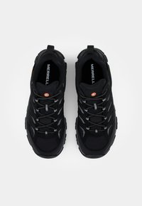 Black hiking shoes with a mesh upper, textured design, reflective laces, and a sturdy rubber sole. Features a logo on the tongue.