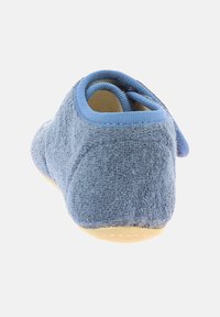 Miękka niebieska tkaninowa ior z teksturowaną powierzchnią, zaokrąglonym tyłem i elastyczną żółtą podeszwą. Zawiera niebieski pasek z tkaniny zapewniający pewne dopasowanie.