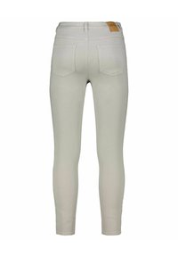 Svetle šedé kalhoty slim fit, s mírným vzestupem pasu, dvěma zadními kapsami a logem na pase. Hladká textilie.