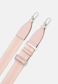 Cinghia per spalla in tessuto rosa con accenti in pelle, dotata di accessori in metallo argento e una fibbia scorrevole. Superficie texturizzata con strisce orizzontali.