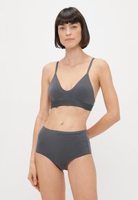 Šedá bavlnená podprsenka s nastaviteľnými ramienkami a textúrovaným pásom. Skombinovaná s vysokými šedými bavlnenými nohavičkami s malým logom na boku.