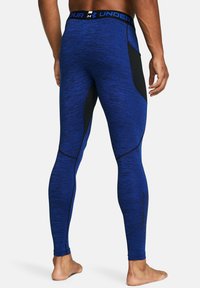 Blaue Sportleggings mit schwarzen Akzenten, aus strukturiertem Material gefertigt. Sie bieten eine enge Passform und verstärkte Nähte entlang der Nahtstellen.