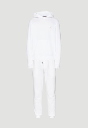 Biała bawełniana hoodie z kieszenią z przodu i długimi rękawami, w parze z dopasowanymi spodniami dresowymi z elastycznymi mankietami i sznurkiem w talii.