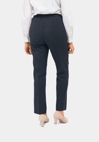 Donkerblauwe dresspants met een elastische tailleband, gecombineerd met lichtbeige hakken, met een slim fit en een gladde textuur.