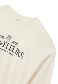 Felpa color crema con colletto rotondo, texture a costine, ricamo floreale e testuale nero sul davanti, e vestibilità comoda.