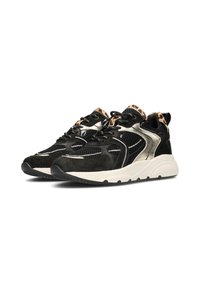 Las zapatillas negras y doradas presentan una combinación de materiales de ante y malla, con una parte superior texturizada, patrones distintivos y una suela blanca gruesa.