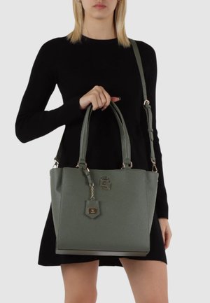 Borsa a tracolla verde in ecopelle con due manici superiori, tracolla staccabile, dettagli in hardware dorato e un'etichetta appesa. Finitura liscia al tatto.