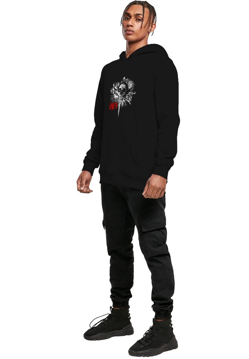 Sweat à capuche noir avec un design graphique présentant un crâne et un motif d'explosion ; fabriqué en matériau doux avec une poche avant et une capuche réglable.