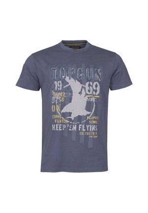 T-shirt bleu avec le texte "TOP GUN", un graphique d'avion blanc et des textes et chiffres militaires supplémentaires en jaune et blanc sur le devant.