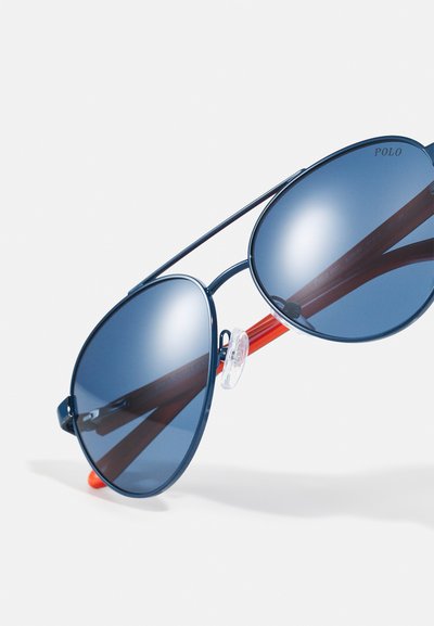 Óculos de sol estilo aviador com lentes azuladas, armação em metal azul marinho, detalhes em borracha vermelha nas hastes e almofadas ajustáveis no nariz para conforto.