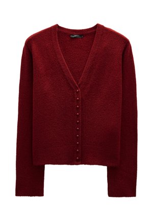 Czerwony sweter z fakturą, z dekoltem w serek, długimi rękawami i rzędem dekoracyjnych guzików z przodu. Miękka tkanina.