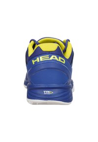 Blaue Sportschuh mit strukturiertem Obermaterial. Merkmale helle gelbe Akzente, auffälliges "HEAD"-Logo und eine weiße Sohle mit "TRI N-R-G"-Detail.