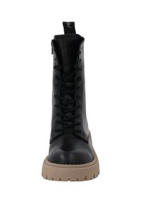 Bota de cuero negro con cordones, puntera redondeada, caña alta, suela de goma beige gruesa y una lengüeta en la parte posterior.