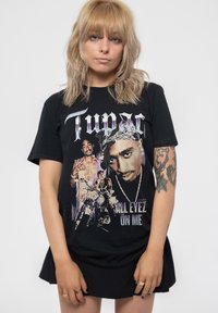 Black cotton T-shirt featuring a graphic print of Tupac with the text "All Eyez on Me." Short sleeves, relaxed fit, with vibrant colors.