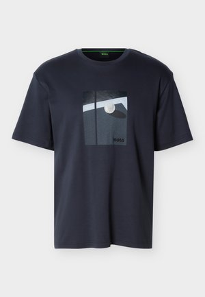 T-shirt à manches courtes bleu marine avec un graphisme d'une balle de golf blanche près d'un trou et le mot « BOSS » imprimé sur le devant.