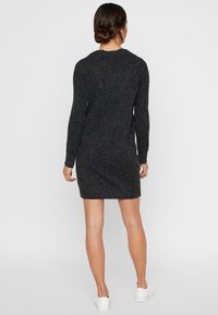 Robe pull gris foncé à manches longues, col arrondi et silhouette ajustée, réalisée en maille texturée.