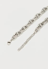 Ασημένιο κολιέ με μεγάλα οβάλ κρίκους και ρυθμιζόμενο προέκταση αλυσίδας σε λευκό φόντο.