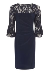 Tmavě modré šaty ke kolenům s krajkovým průkrčníkem a rukávy, rozšířenými krajkovými manžetami a záhyby na přední straně.