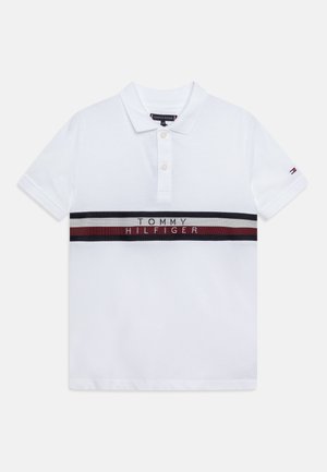 Biała koszulka polo z krótkim rękawem, dwoma guzikami, pozioma paski w kolorach granatowym, białym i czerwonym na wysokości klatki piersiowej, napis "Tommy Hilfiger" oraz małe logo flagi na rękawie.