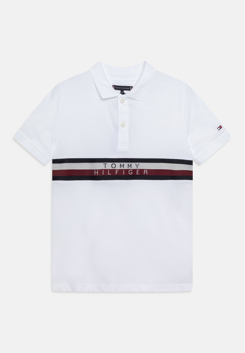 Polo blanc à manches courtes avec deux boutons, bande horizontale bleu marine, blanche et rouge sur la poitrine, texte "Tommy Hilfiger" et petit logo drapeau sur la manche.